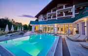 Das Hotel besitzt einen gro&szlig;en Aussenpool der beleuchtet wird w&auml;hrend im Hintergrund die Sonne untergeht