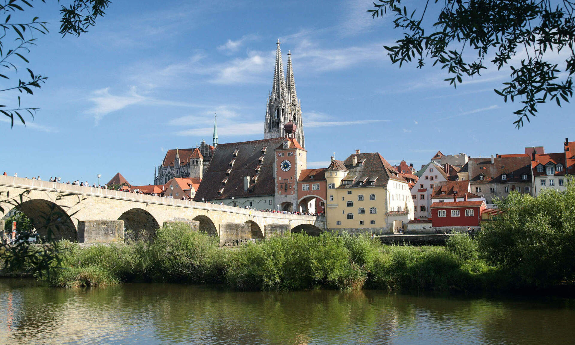 Eine malerische Steinbrücke überspannt den Fluss vor der Altstadt von Regensburg.